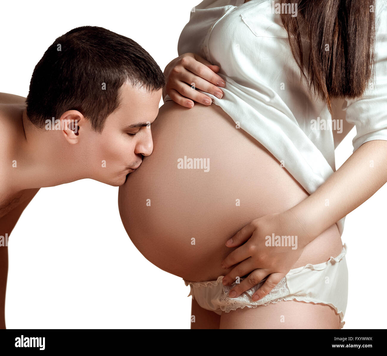 Marido besa la barriga de su esposa embarazada Foto de stock
