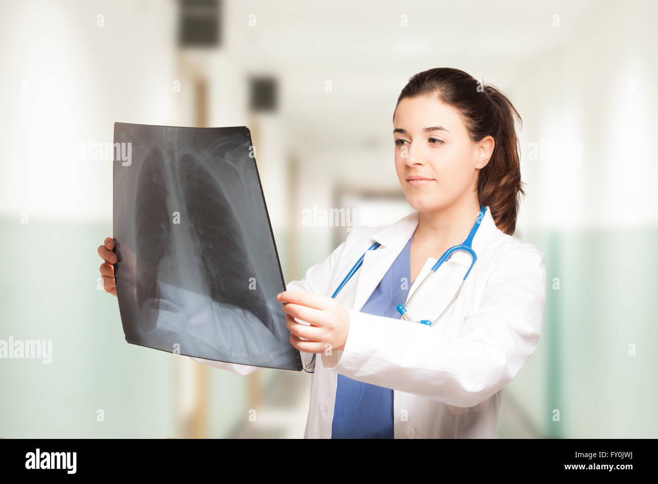 Las hembras jóvenes caucásicos médico mirar una radiografía Foto de stock