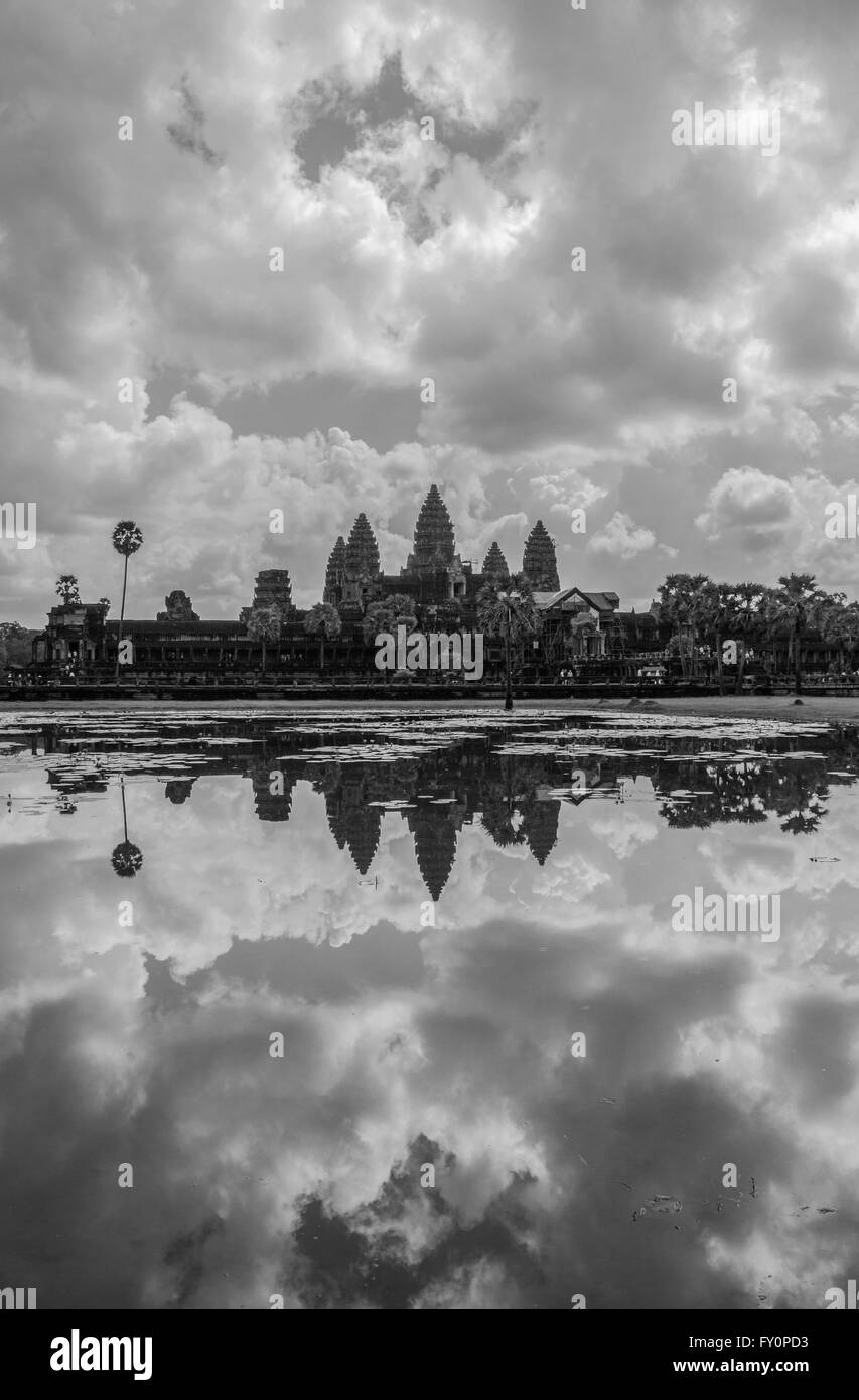 Vista del templo de Angkor Wat al otro lado del charco, en medio de una reflexión de un impresionante cielo nublado Foto de stock