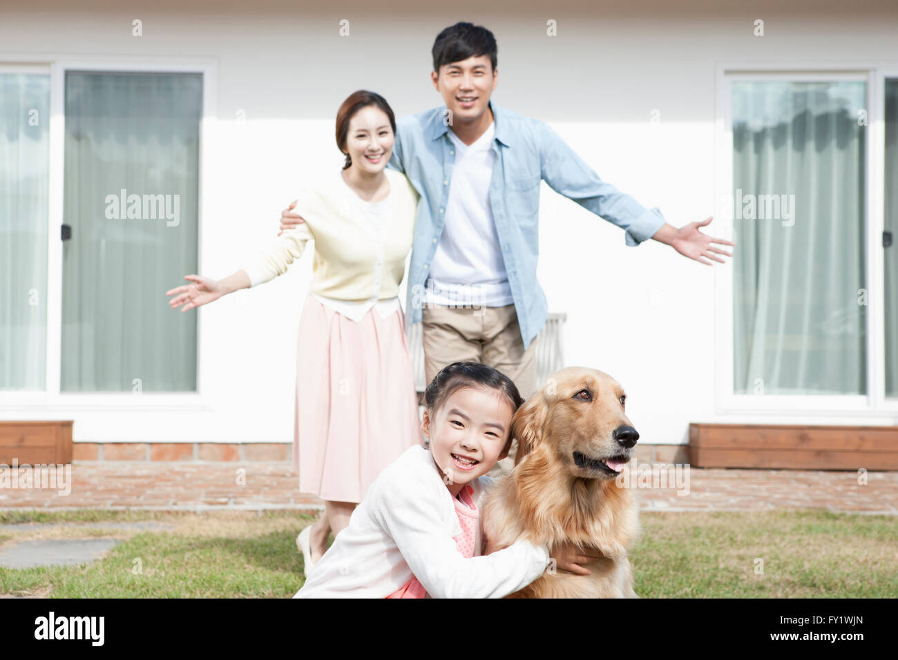 Familia con un perro en el patio de su casa en Jeju que representan la vida rural Foto de stock