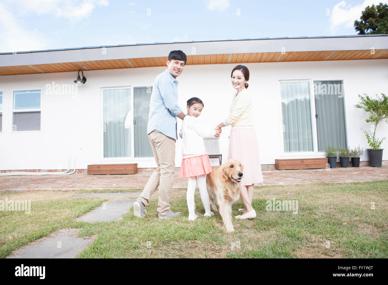 Familia con un perro en el patio de su casa en Jeju que representan la vida rural Foto de stock