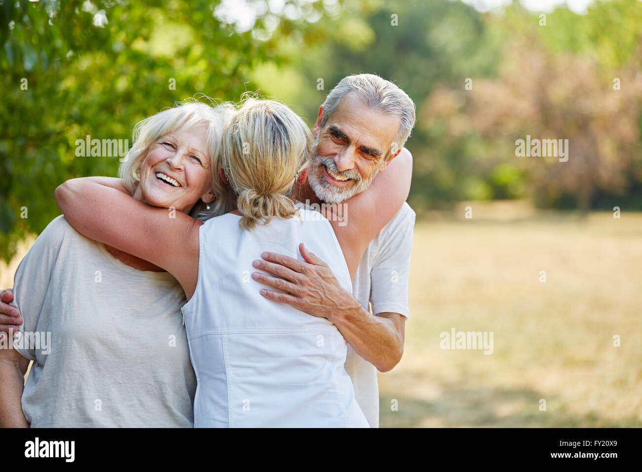 Feliz amigos senior abrazarse mutuamente en el jardín en verano Foto de stock
