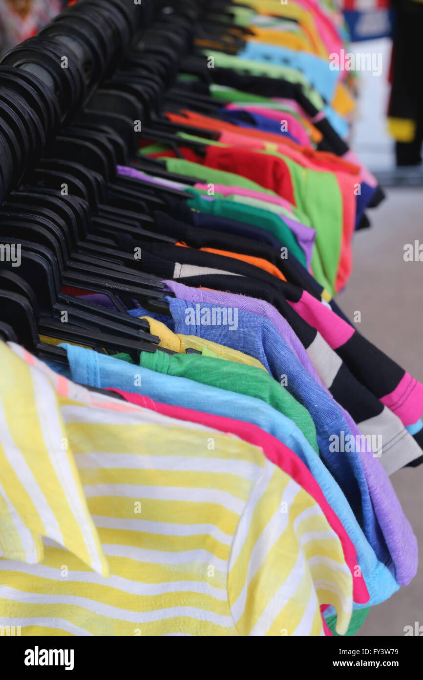 Camisas de moda colgando de un tendedero,tienda de ropa. Foto de stock