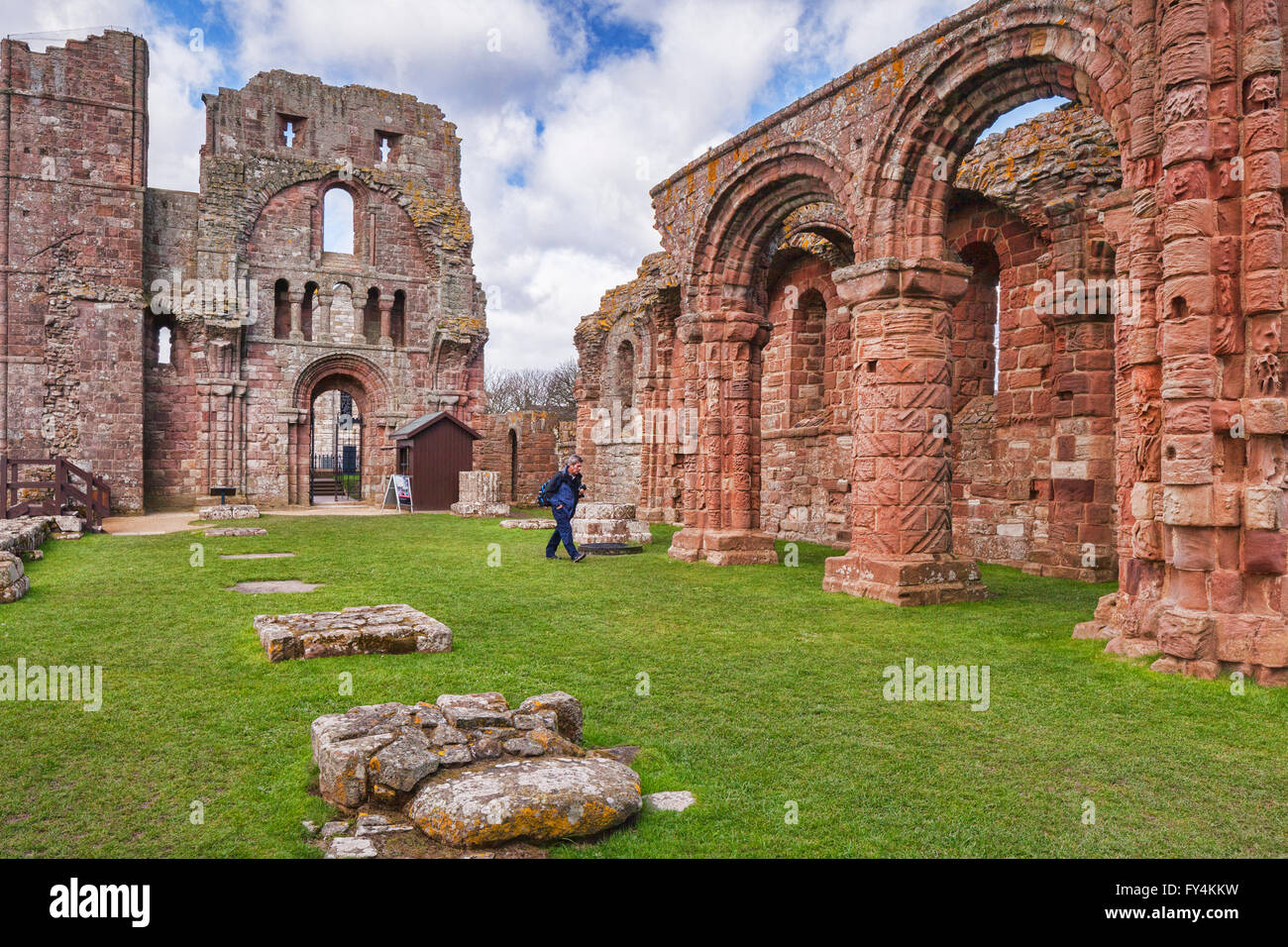 Visitante en las ruinas de Lindisfarne Priory, Holy Island, Northumberland, Inglaterra, Reino Unido. Foto de stock