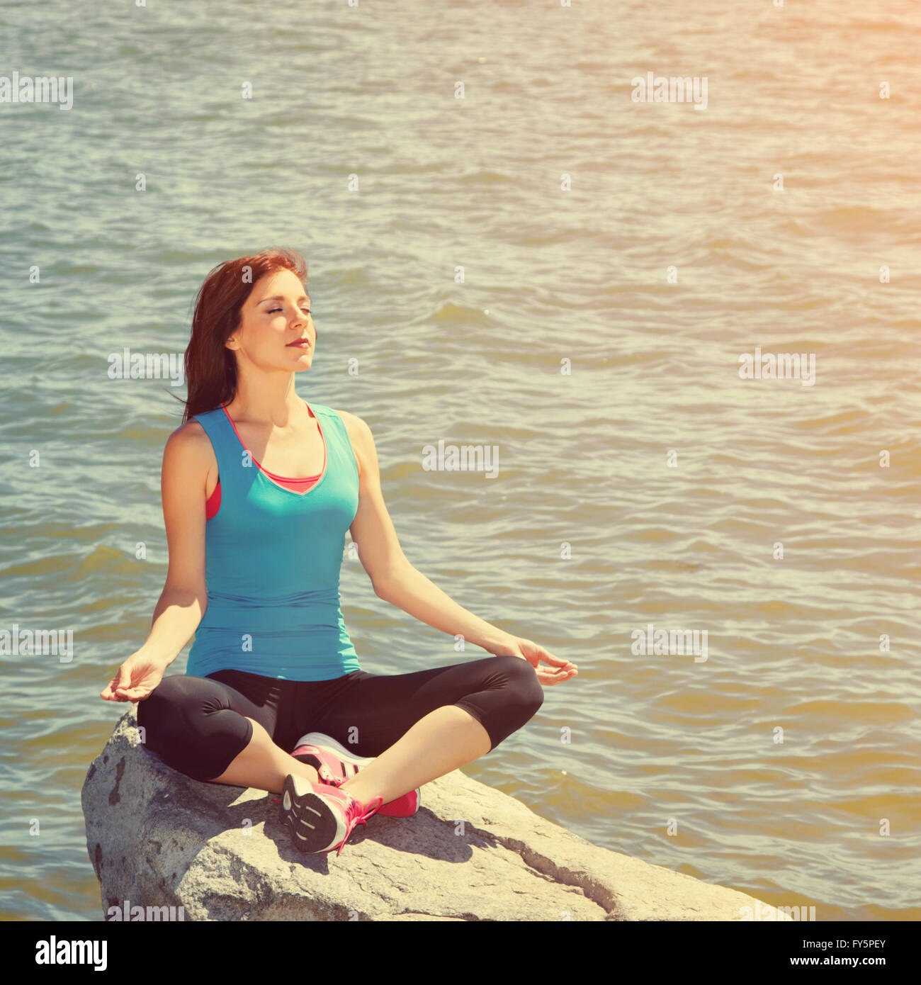 Mujer meditando en la orilla del mar Foto de stock