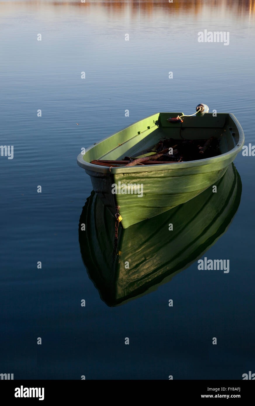Fila única embarcación en el lago con el reflejo en el agua Foto de stock