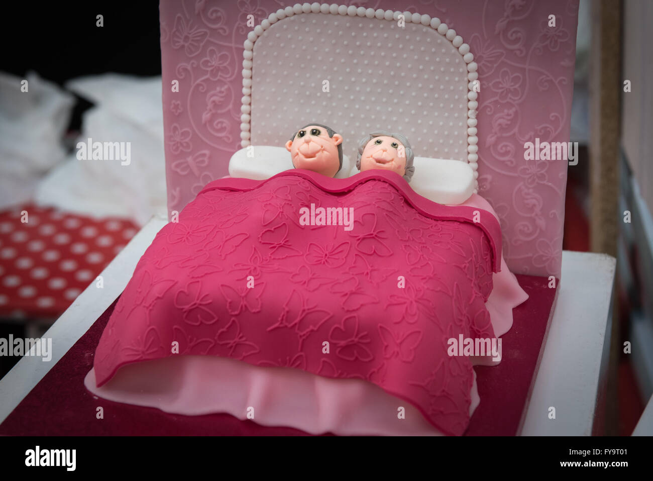 Vieja pareja hombre mujer en la cama para dormir en torta comestible Internacional - El Sugarcraft, decoración de pasteles y hornear Show en Londres Foto de stock