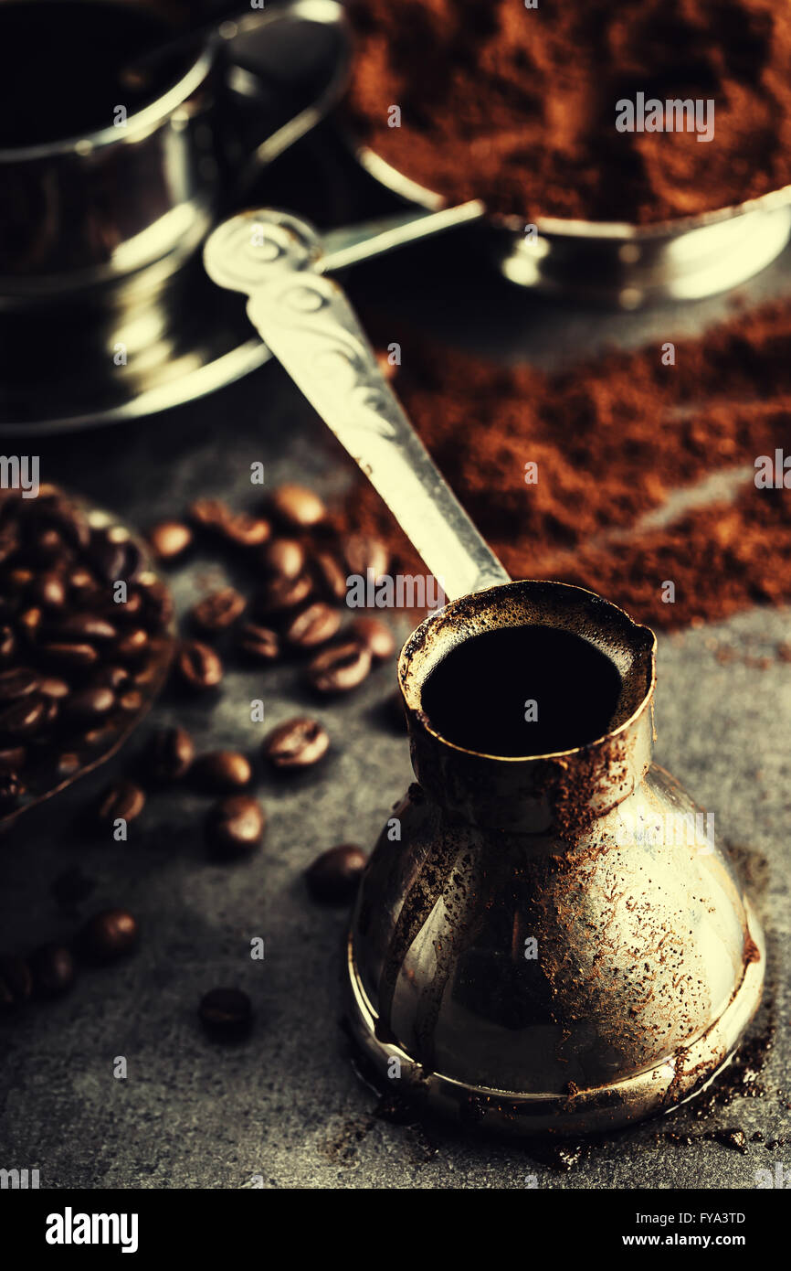 Cafetera turca caliente, frijoles y chocolate en mesa de madera Fotografía  de stock - Alamy