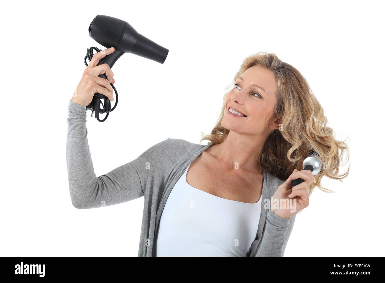 Mujer de pelo largo con el secador y un cepillo redondo grande Fotografía  de stock - Alamy