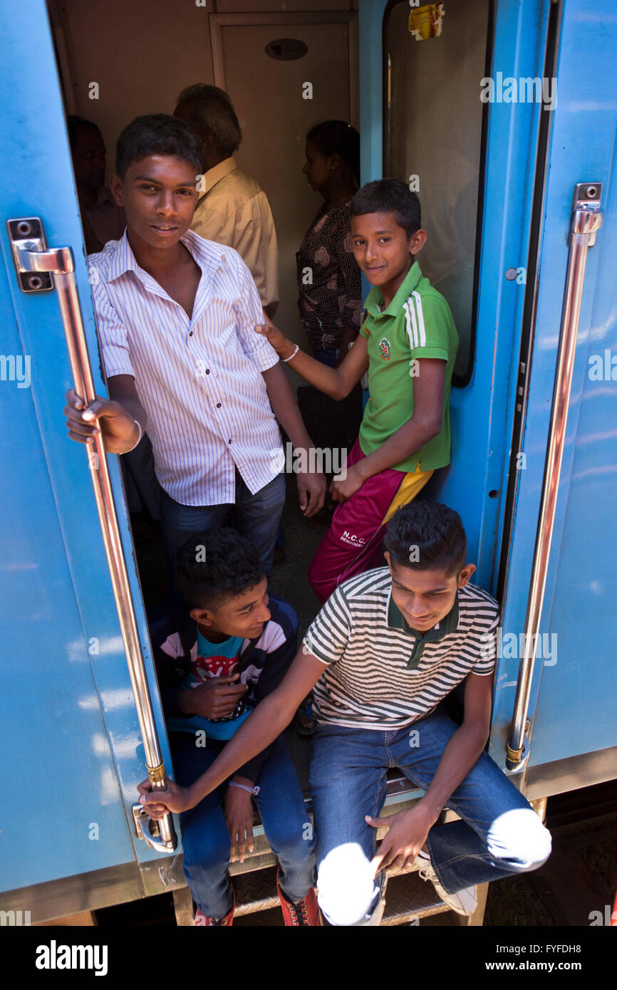 Sri Lanka, Ohiya estación ferroviaria, los jóvenes locales en la puerta del carro hizo chino azul Foto de stock