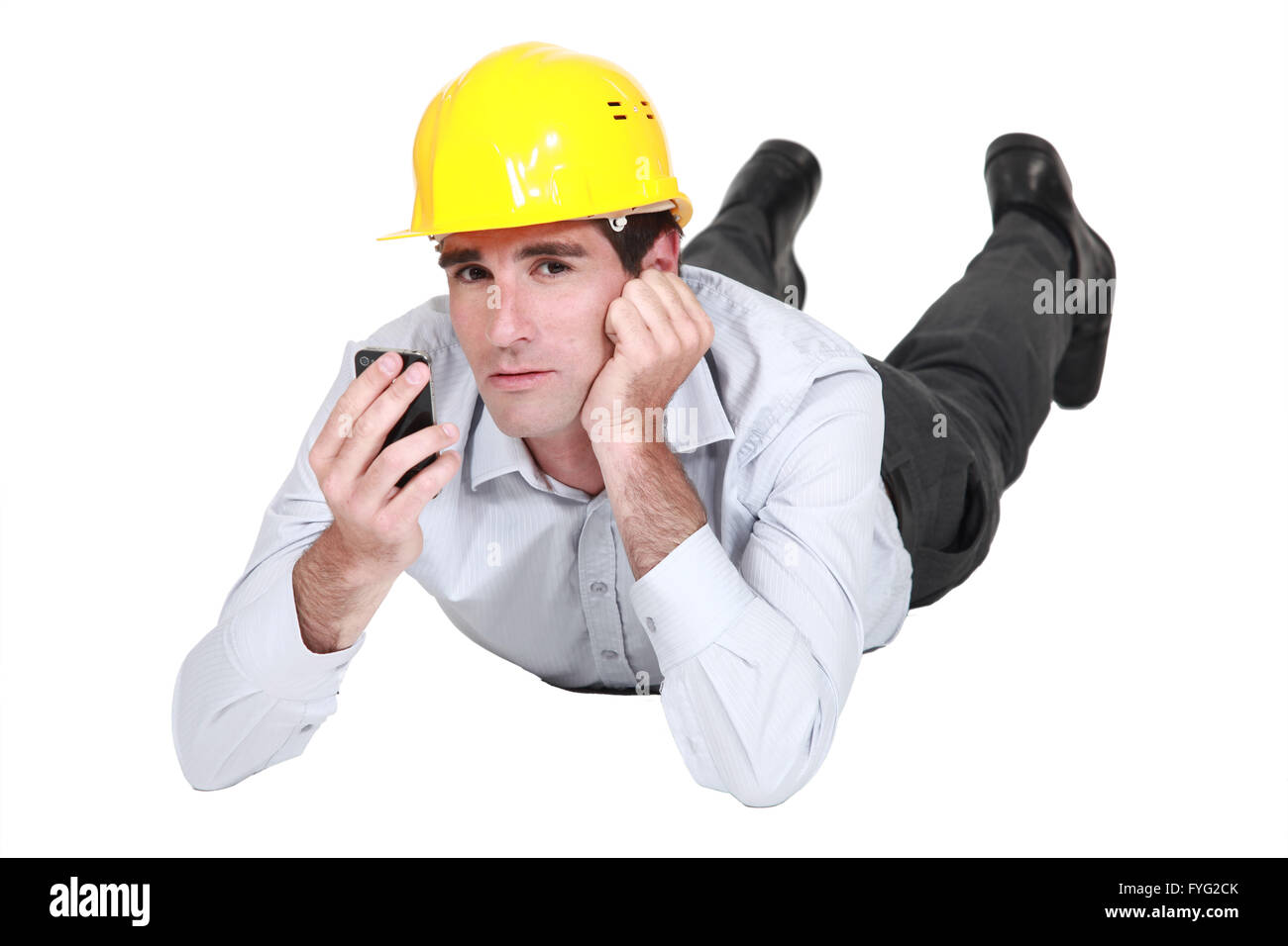 Empresario con casco hablando en su celda. Foto de stock