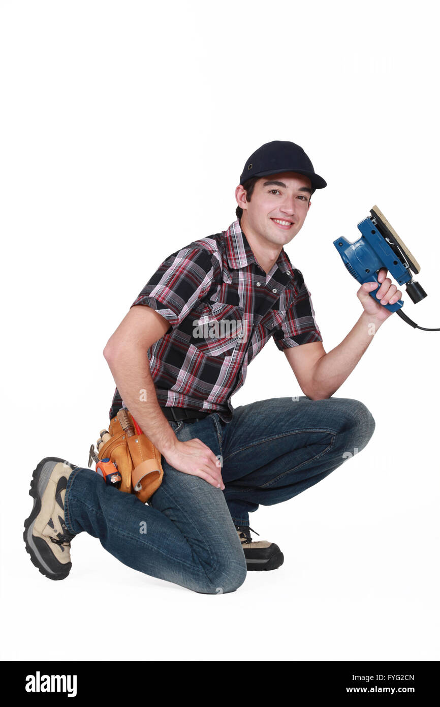 Retrato de joven carpintero con máquina lijadora Foto de stock