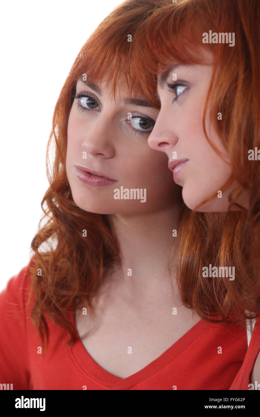 Triste mujer mirando a su reflejo en el espejo Foto de stock