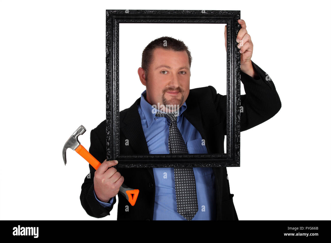 Hombre en un traje con un martillo y un marco de imagen Foto de stock