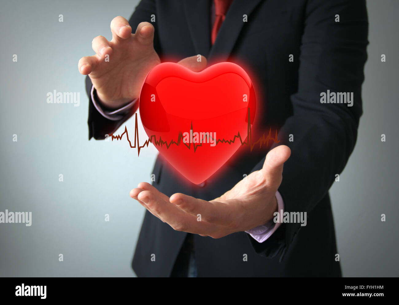 Los seguros de salud o amor concepto concepto: hearth con electro en manos de un empresario Foto de stock