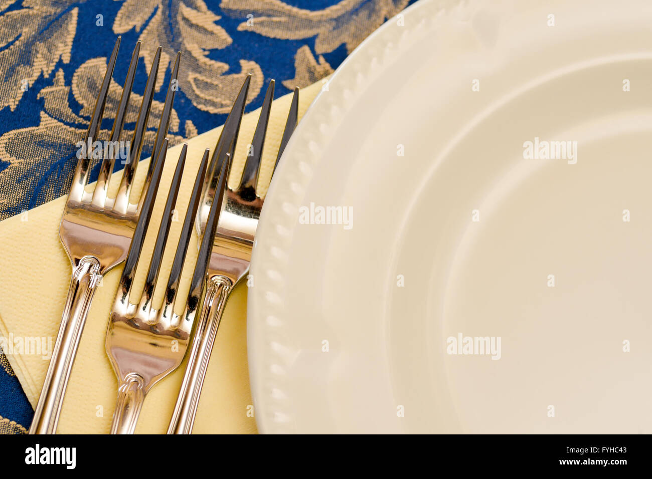Tres horquillas y china blanco placa en una tabla Foto de stock