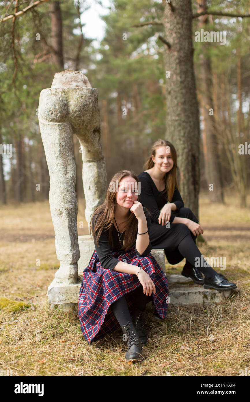 Dos amigas sentado cerca de la destruida arte Sots monumento en el parque antiguo. Foto de stock