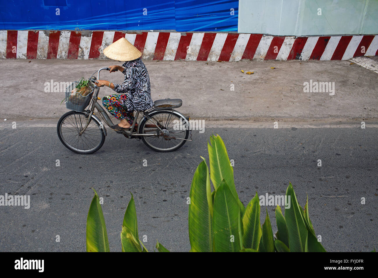 Una mujer en bicicleta en la ciudad de Ho Chi Minh, Vietnam Foto de stock