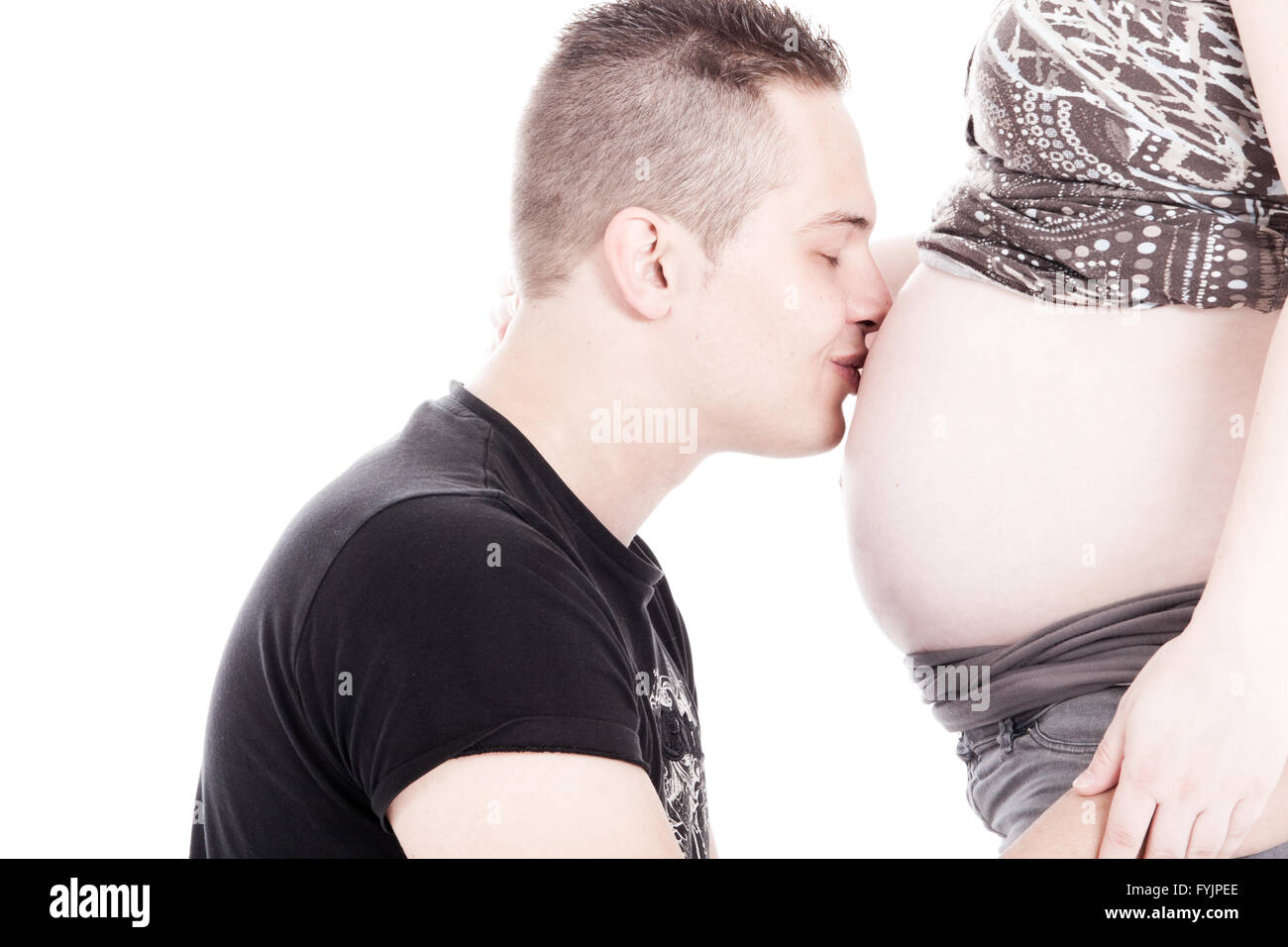 Anuncio del embarazo, las mujeres embarazadas besan a su marido después de  revelarle que está embarazada con zapatos para bebés Fotografía de stock -  Alamy