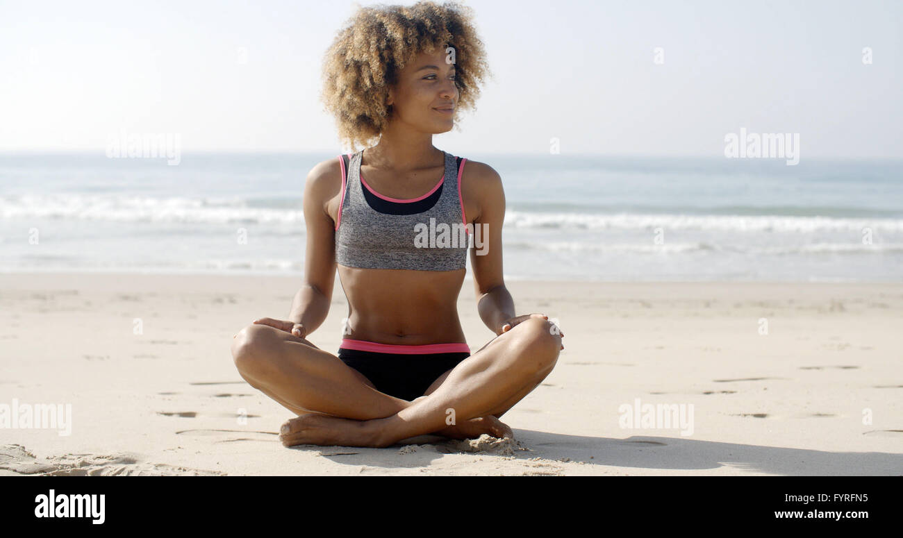 Colocar Mujer sentada en la playa Foto de stock