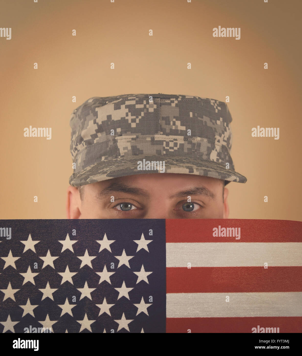 Un soldado del ejército militar está sosteniendo una bandera americana hasta su rostro con un uniforme y copyspace para un veterano, memorial o él Foto de stock