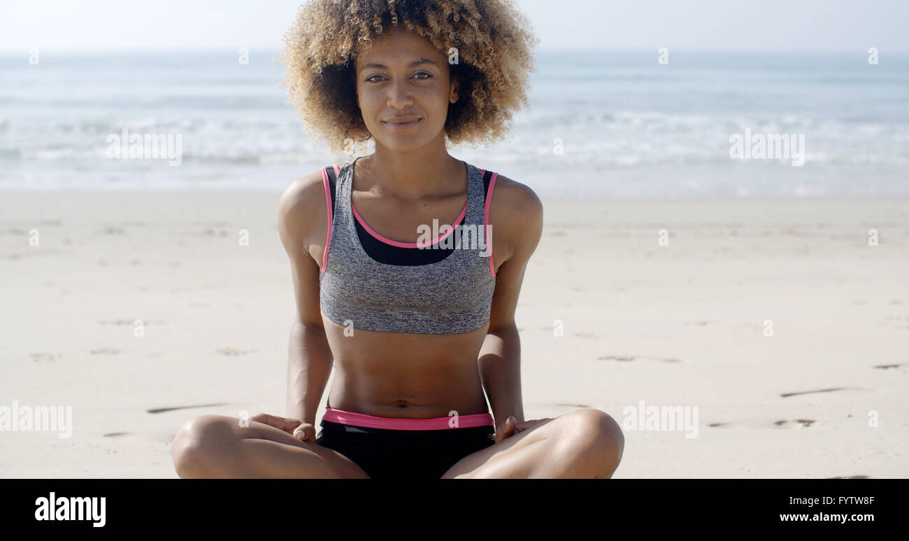 Colocar Mujer sentada en la playa Foto de stock