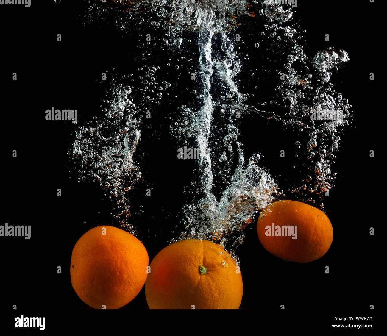 Las naranjas caigan en el agua Foto de stock