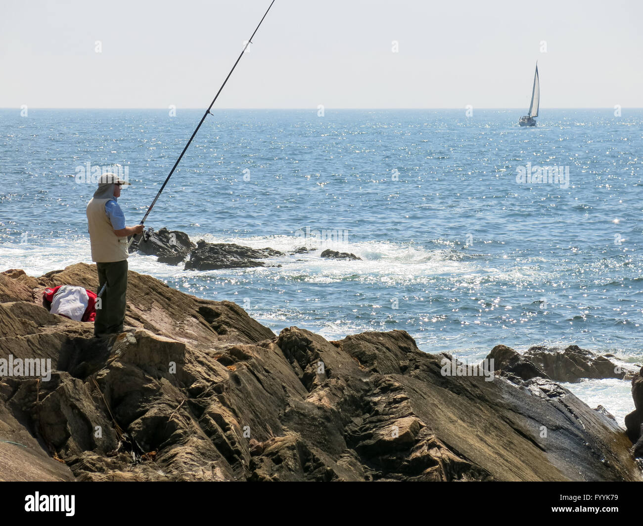 Pescador pesca en el Océano Atlántico y el velero navegando en el mar frente a la costa de Foz cerca de Porto, Portugal Foto de stock