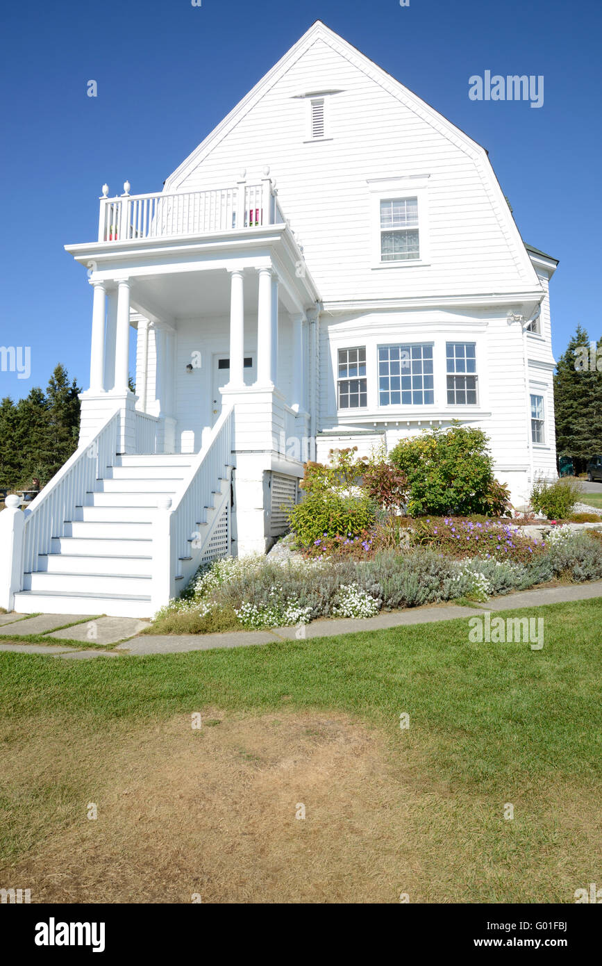 Exterior de una vieja casa blanca en la costa de Maine. La casa es de color  blanco, con escalones que llevan a la puerta principal. Hay un obtenido  resultados positivos Fotografía de