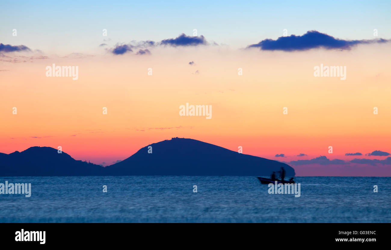 Amanecer sobre el mar Negro con silueta de personas en barco Foto de stock