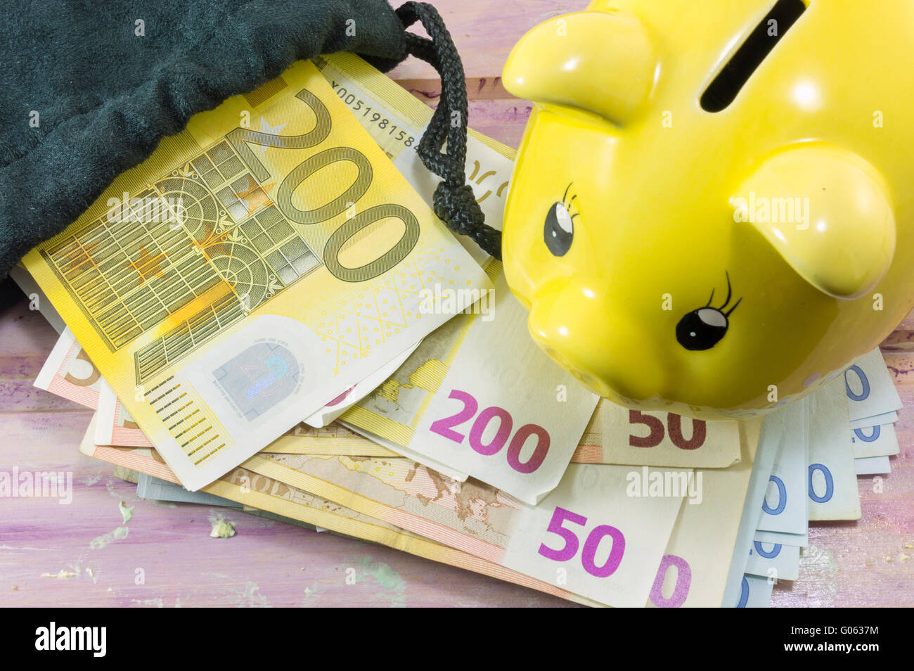Billetes de Euro y hucha en la mesa Foto de stock