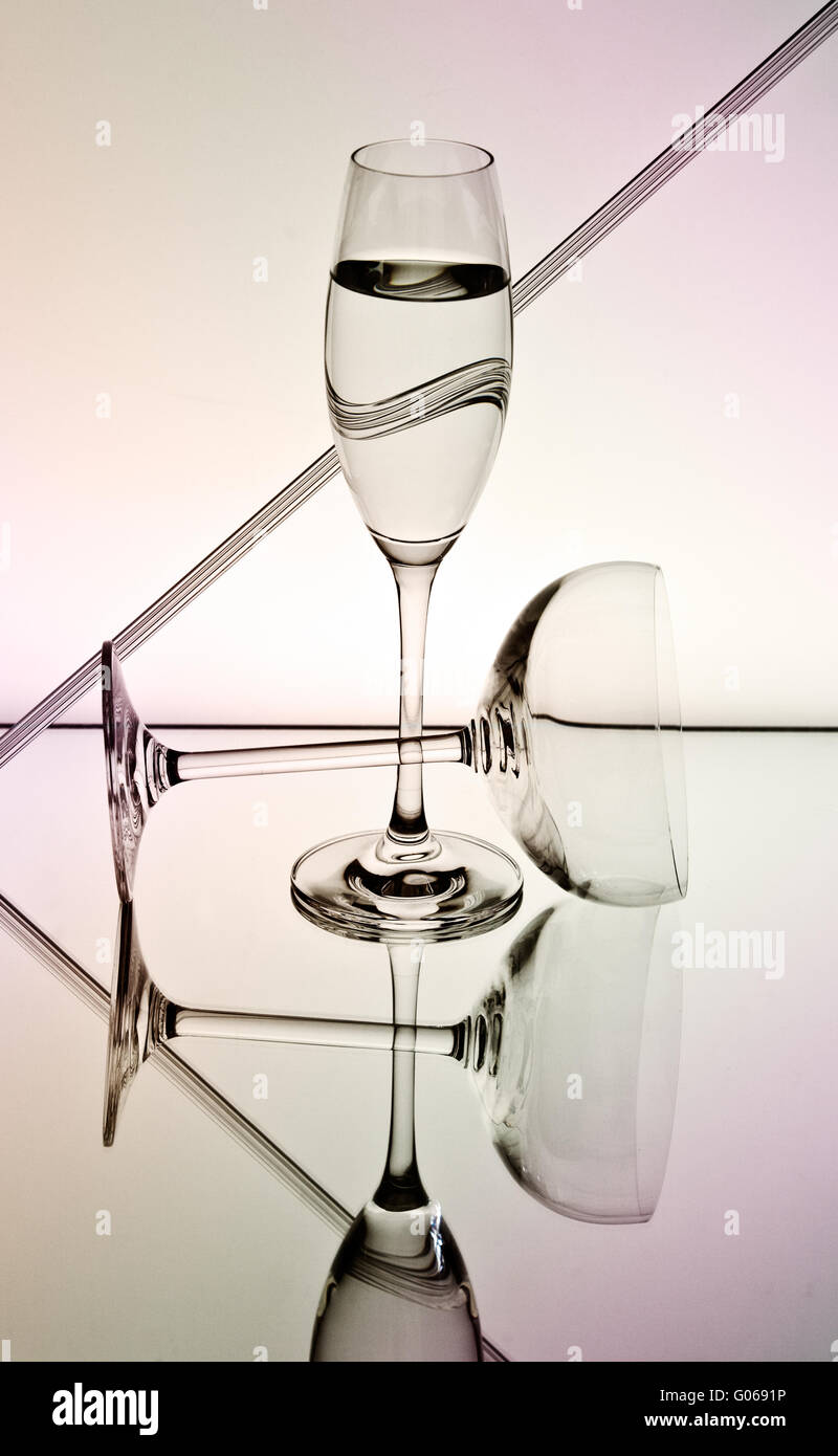Copas de champaña en la superficie del espejo y fondo degradado suave Foto de stock