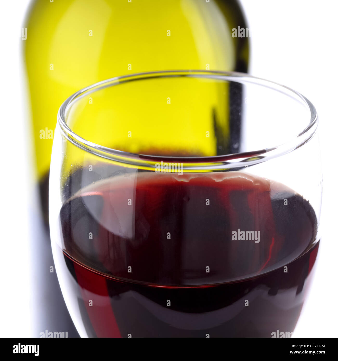 Vaso de vino tinto con una botella de vino antecedentes Foto de stock
