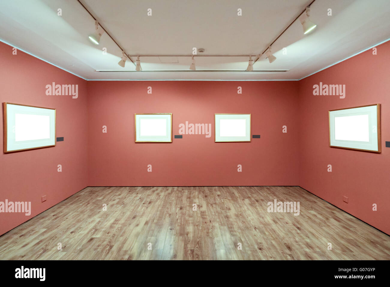 Marco de imagen en blanco en una habitación contra la pared de exhibición Foto de stock