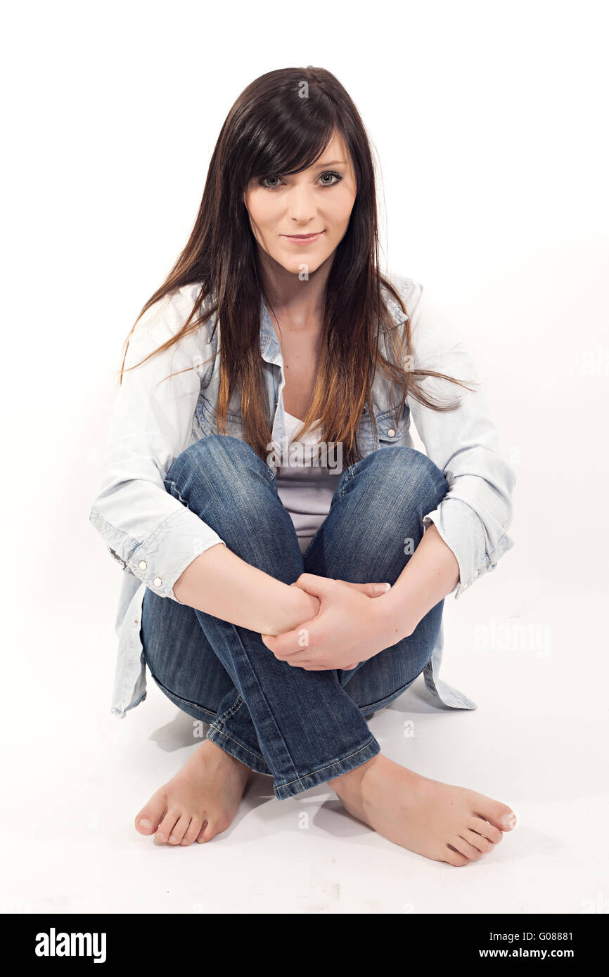 Retrato de una joven y bella mujer sentada en el piso Foto de stock