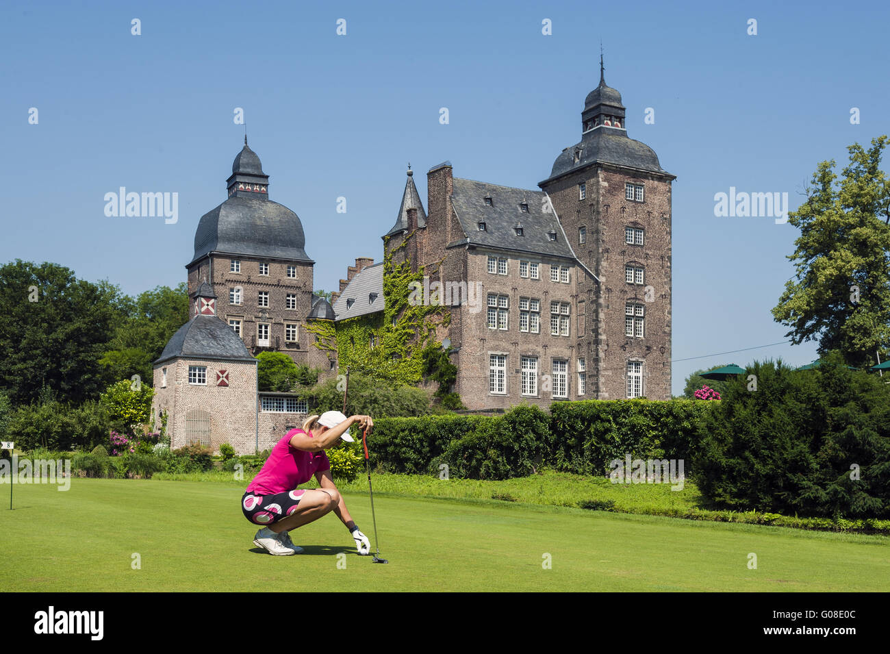 Golfista en cuclillas sobre el césped del golf cours Foto de stock