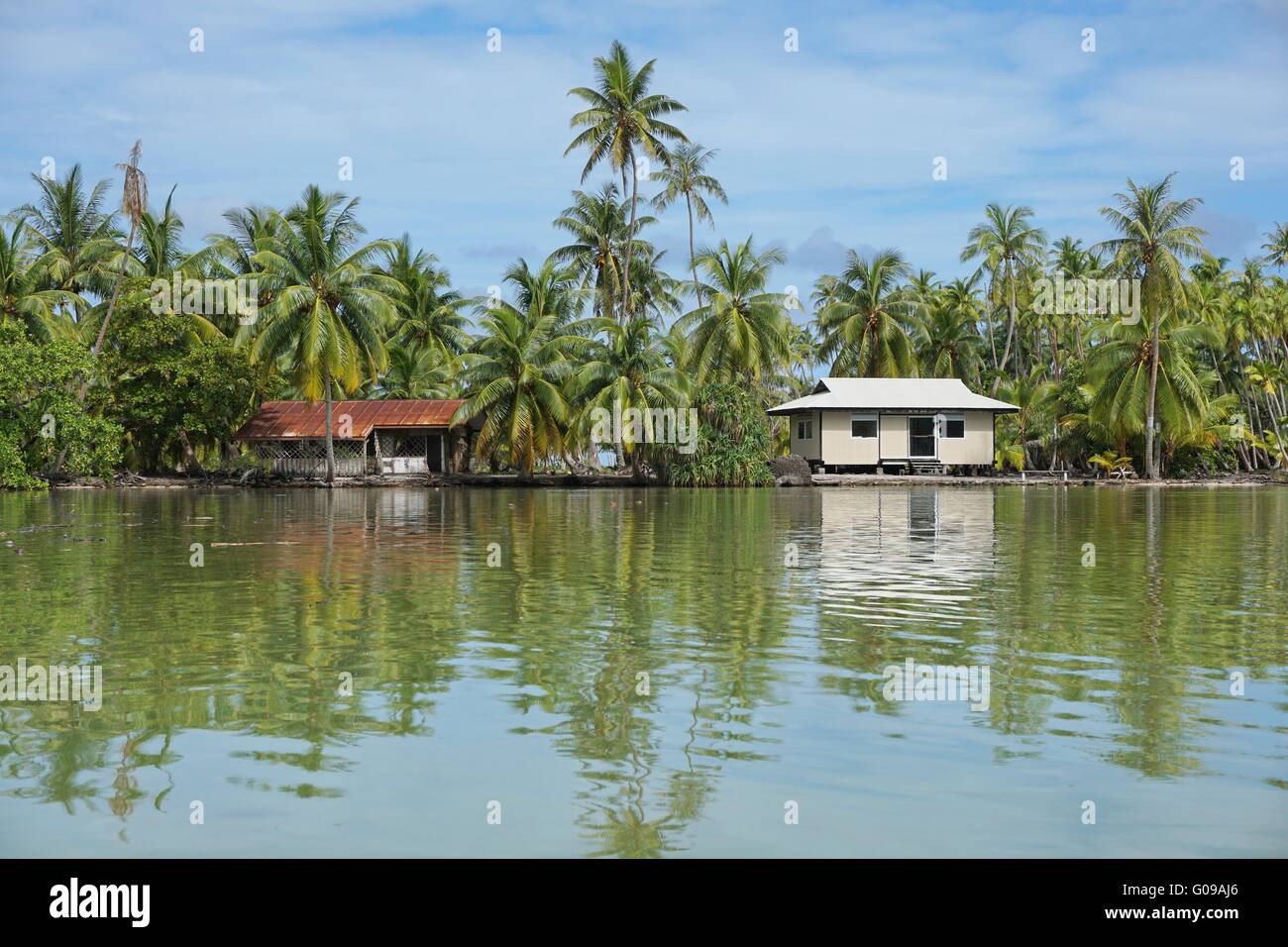 Costa Tropical de un islote con cocoteros y típica casa de Polinesia, Huahine island, Pacífico, la Polinesia Francesa Foto de stock