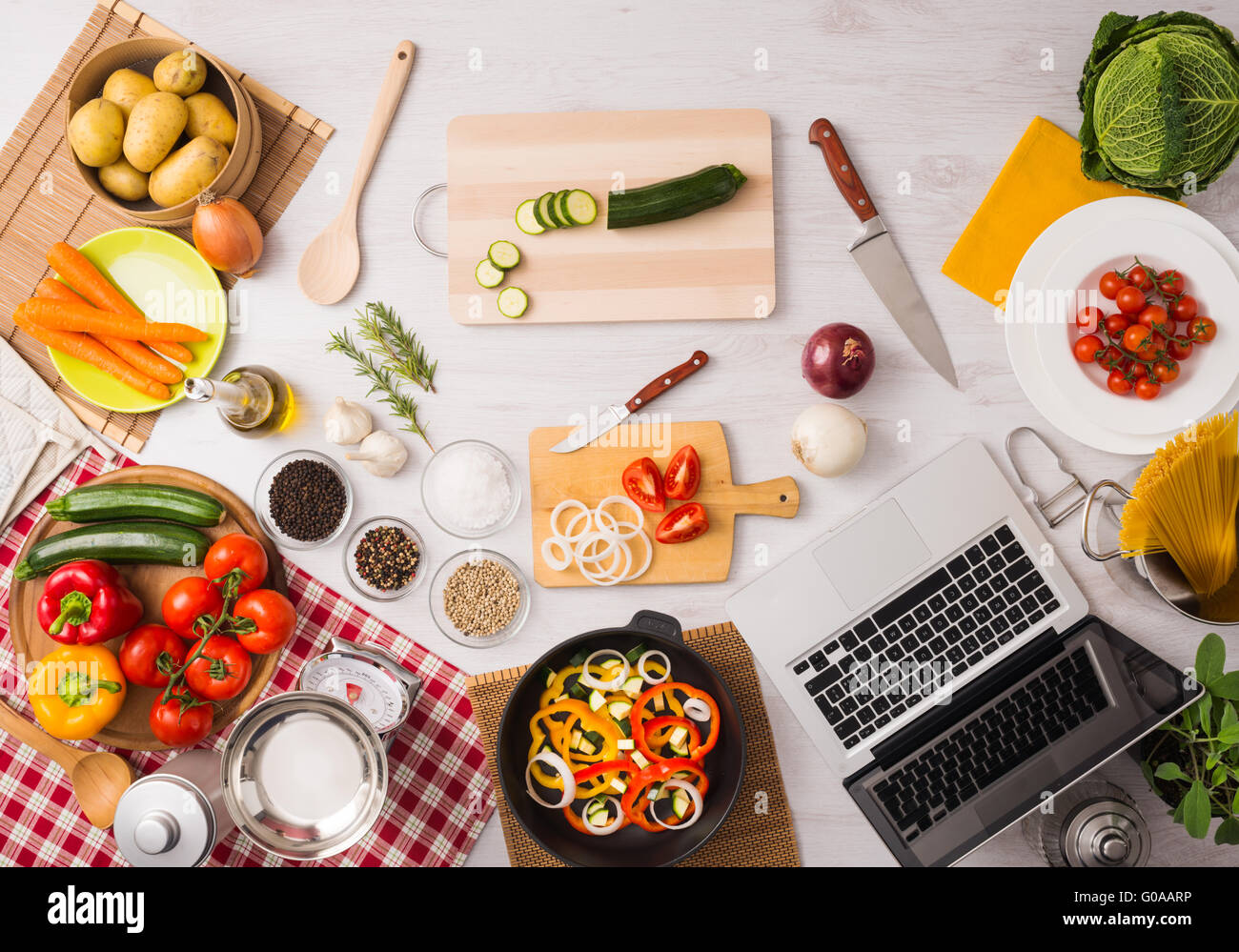 Cocina vegetariana creativa con utensilios de cocina, vegetales frescos y  laptop sobre una mesa de madera, vista superior Fotografía de stock - Alamy