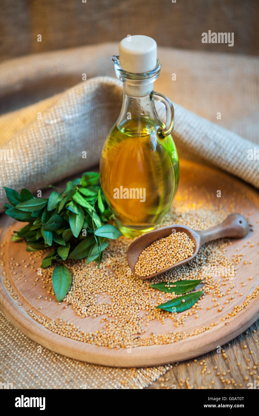 Recipiente con aceite natural y semillas de mostaza sobre mesa de madera