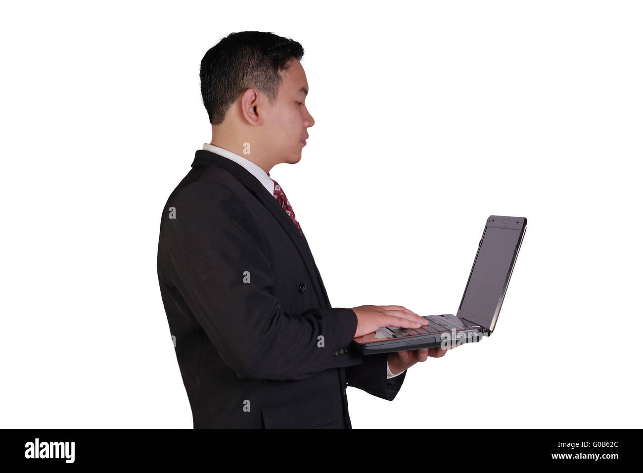 Concepto de negocio la imagen de un empresario asiático mantiene portátil con una mano y escribir con la otra mano aislado en blanco Foto de stock