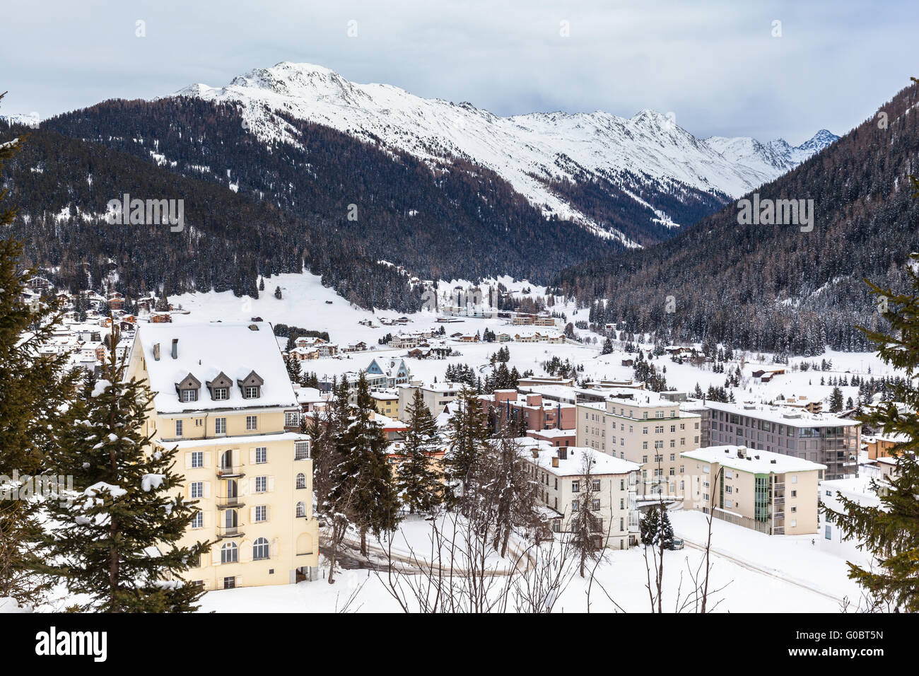 Hermosa vista de Davos en invierno con tejados cubiertos de nieve y los Alpes, en el cantón de los Grisones, Suiza. Foto de stock