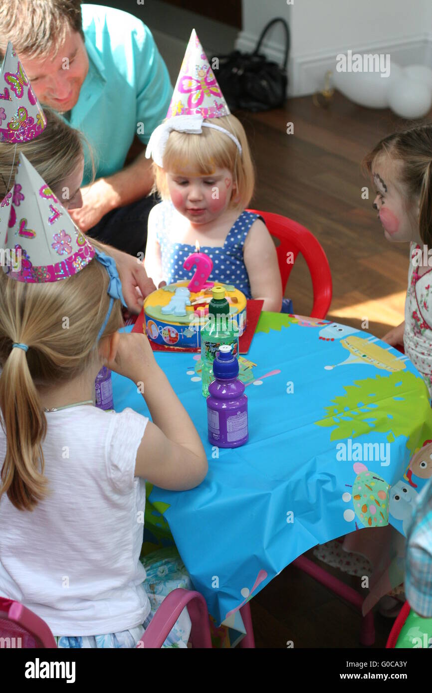 Cumpleaños De Los Niños Celebran La Fiesta Y Pastel En Un Plato Juntos.  Retrato De Tres Niños Niña Feliz Y El Niño En El Sombrero De Fiesta Sentado  Por Tabla. Fotos, retratos