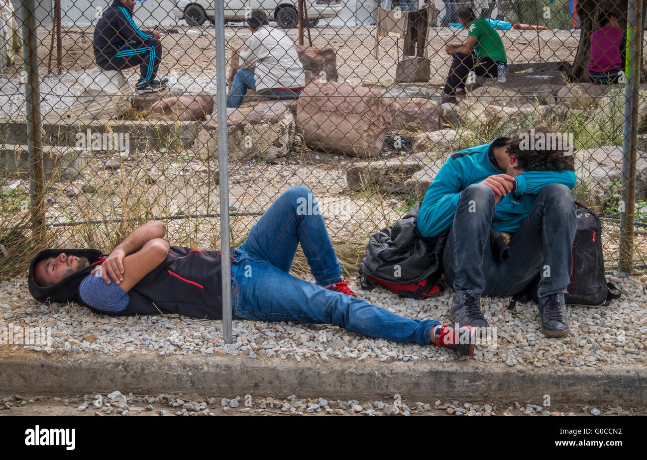 Dos hombres jóvenes refugiadas agotados desde Siria colapso a las puertas del campamento de refugiados de Kara Tepe en la isla griega de Lesbos Foto de stock