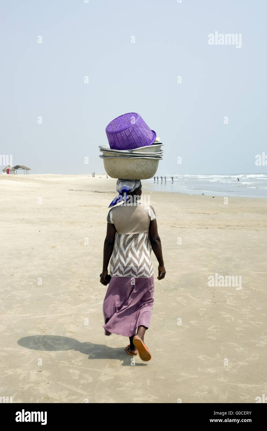 Una mujer africana de Ghana anidan en su cabeza una carga pesada. Foto de stock