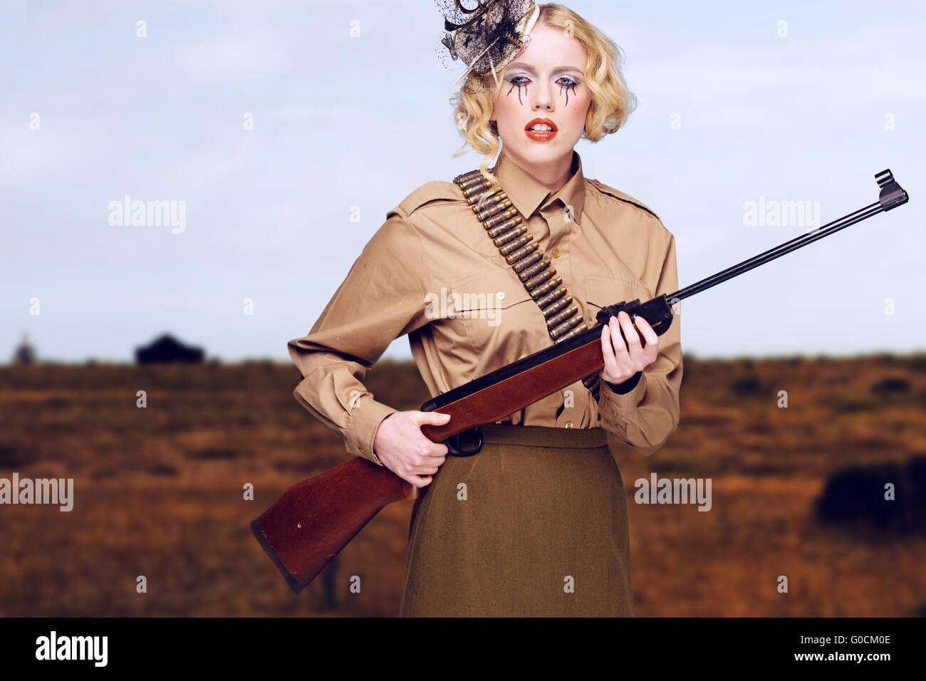 Elegante Girl Scout con pistola en el campo Foto de stock