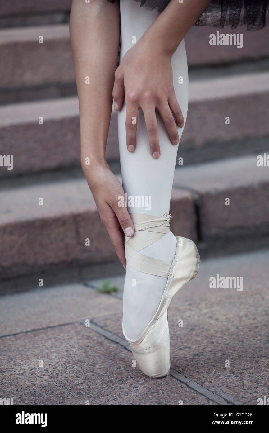 Cuerpo completo de mujer elegante en zapatos blancos de tutú y punta  mirando hacia abajo mientras está de pie contra la pared de hormigón  Fotografía de stock - Alamy