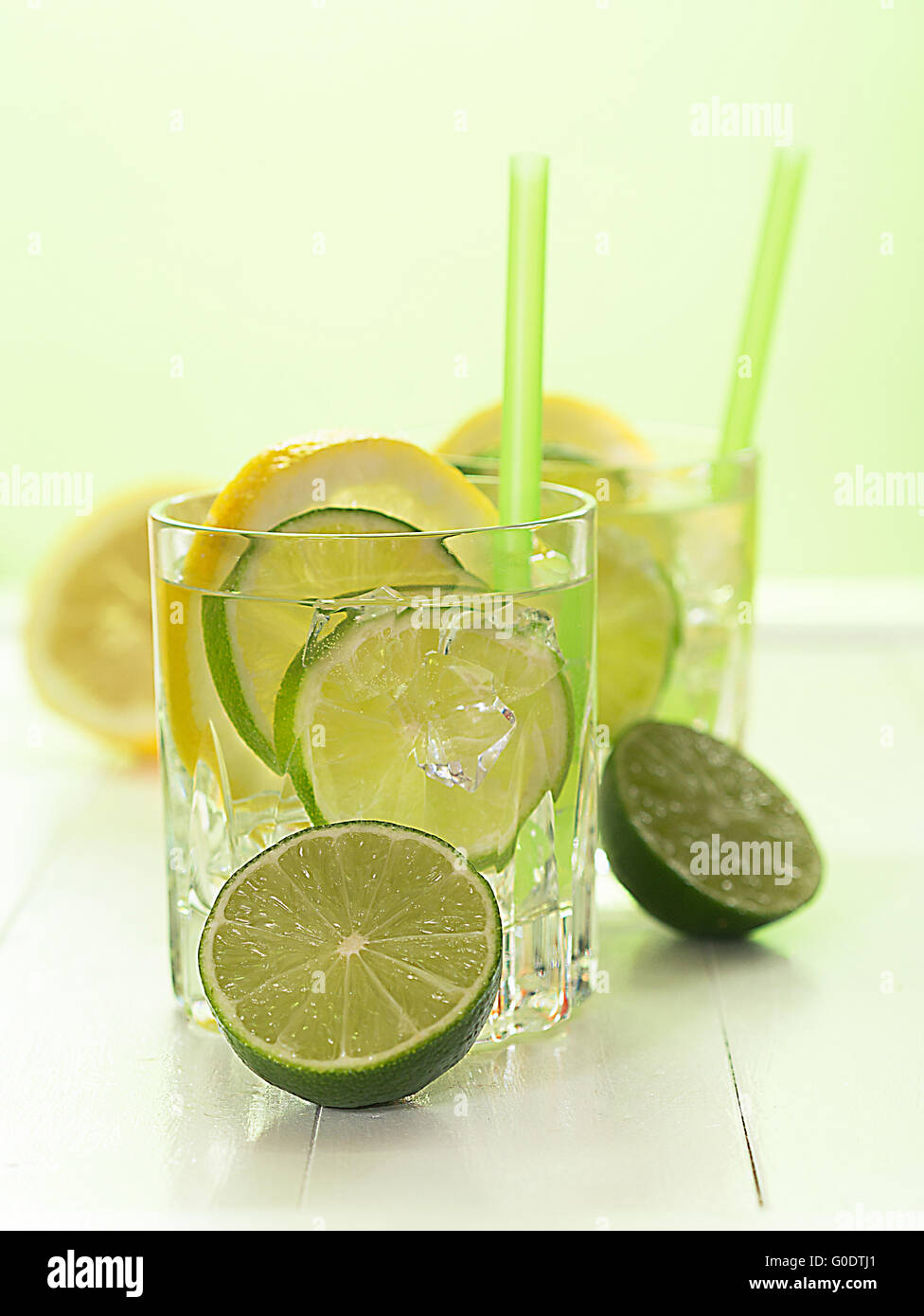 Un vaso de agua con limón y rodajas de limón Foto de stock