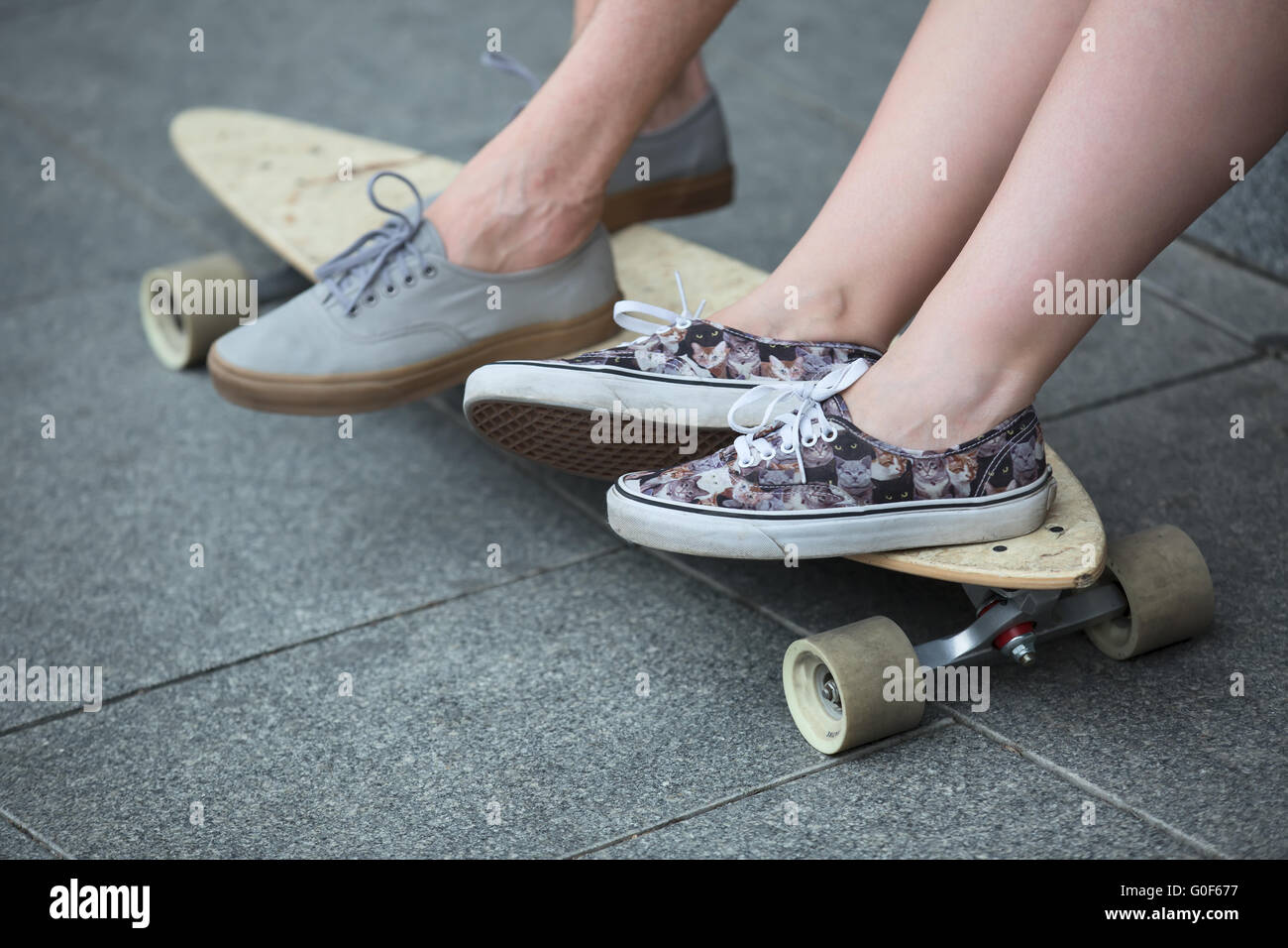 Pies pareja de adolescentes en zapatillas sobre longboard closeup  Fotografía de stock - Alamy