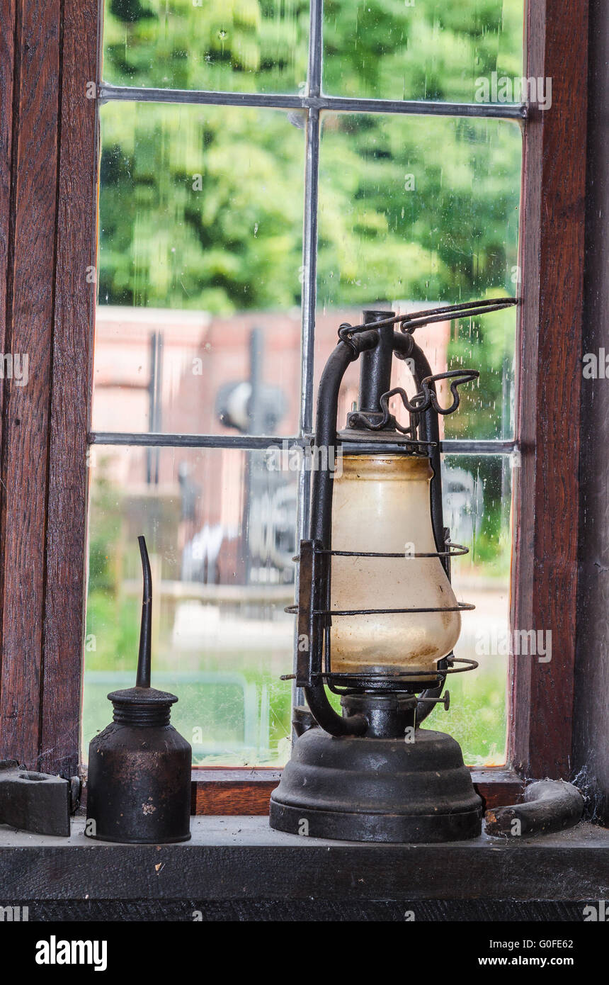 Antigua lámpara de querosén en un alféizar Foto de stock