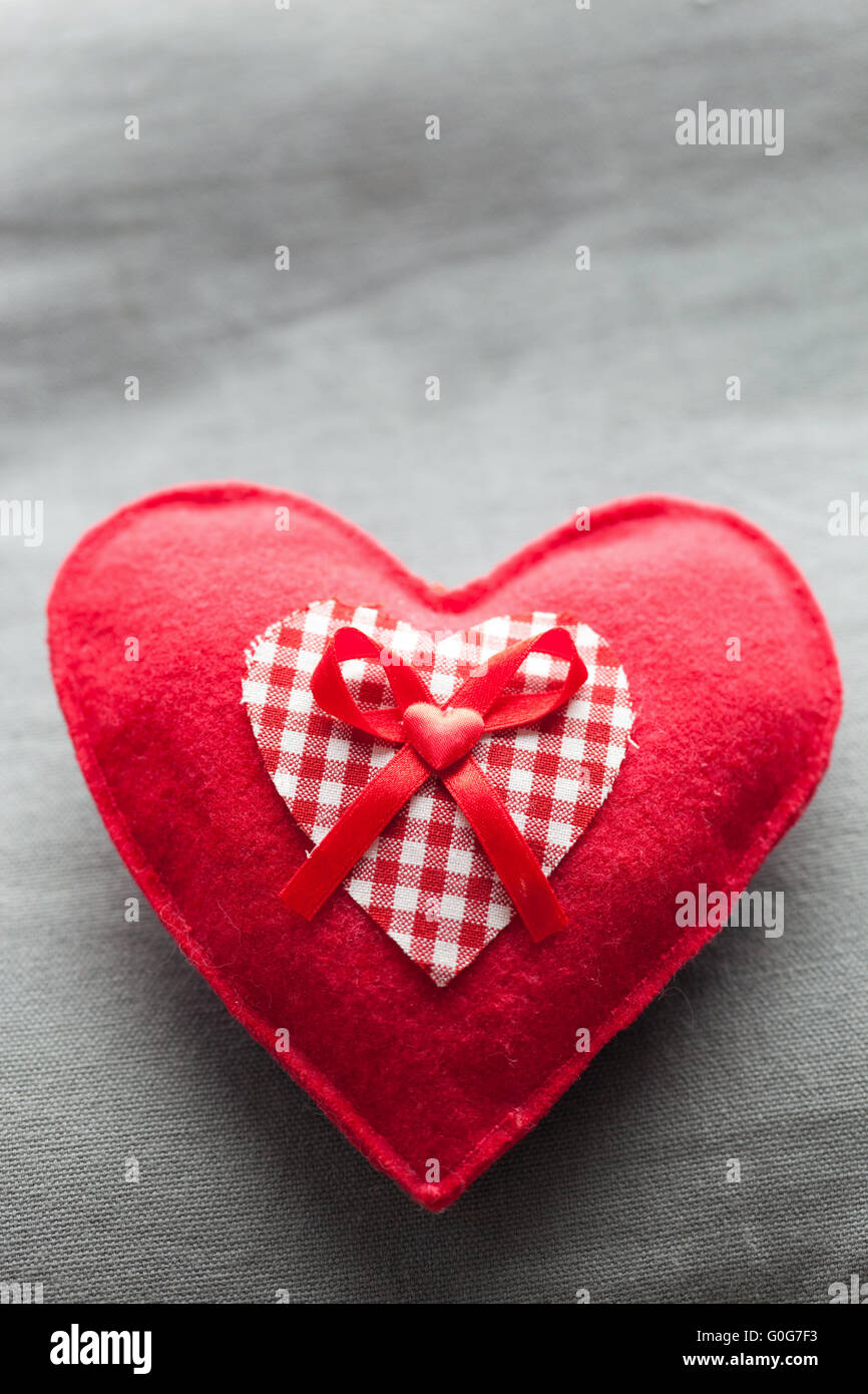 Corazón de felpa roja artesanal en la almohada blanda. El amor romántico Foto de stock